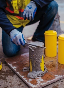 Construction worker filling concrete in a cylinder